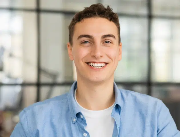 Young man smiling confidently after Invisalign treatment